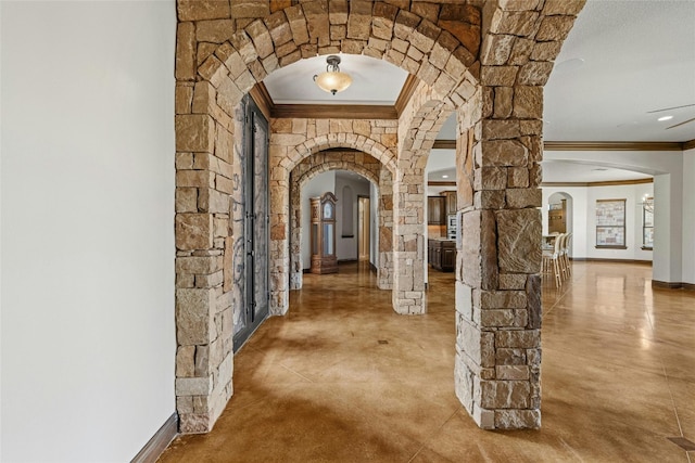 hallway with crown molding and concrete floors