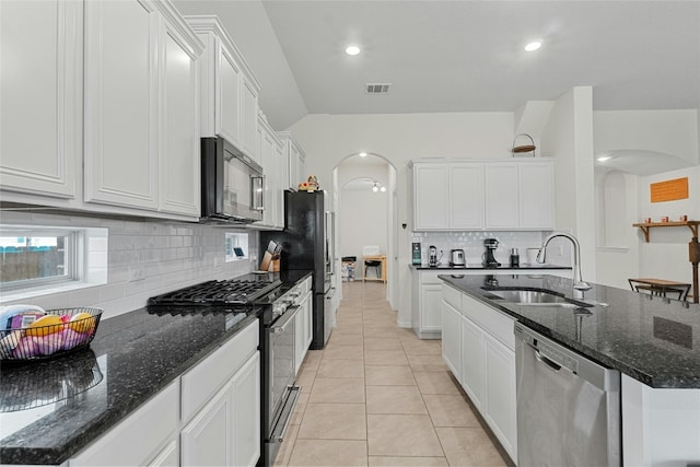 kitchen featuring an island with sink, appliances with stainless steel finishes, sink, and white cabinetry