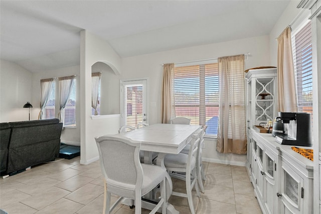 tiled dining room with lofted ceiling