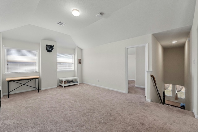 interior space with lofted ceiling and light colored carpet