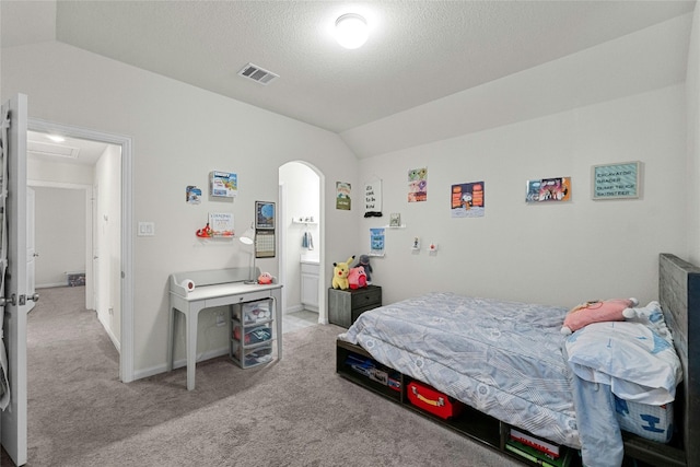 carpeted bedroom with vaulted ceiling and a textured ceiling