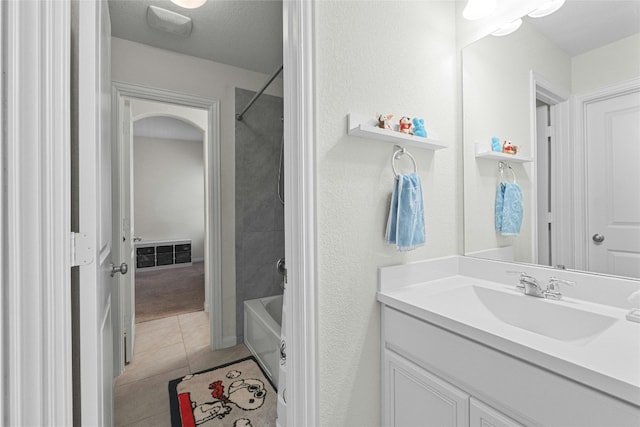 bathroom with tile patterned flooring, shower / bathtub combination, vanity, and a textured ceiling