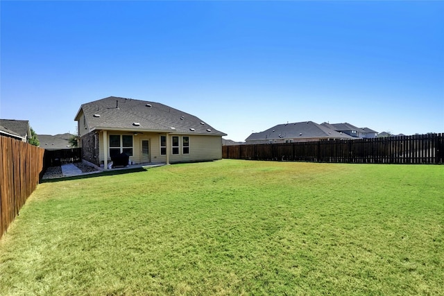 back of house with a yard and a patio