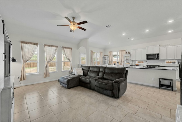 living room with ceiling fan, sink, and light tile patterned floors