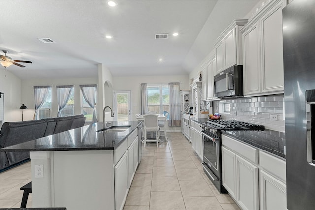 kitchen featuring an island with sink, sink, stainless steel appliances, and white cabinets