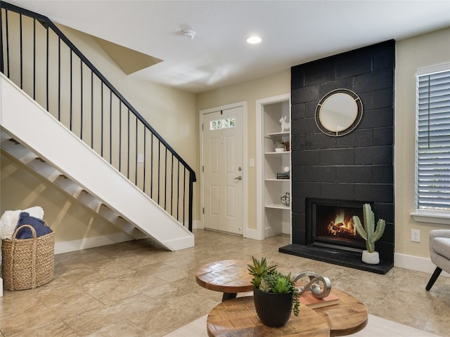 foyer featuring a wealth of natural light and a tile fireplace