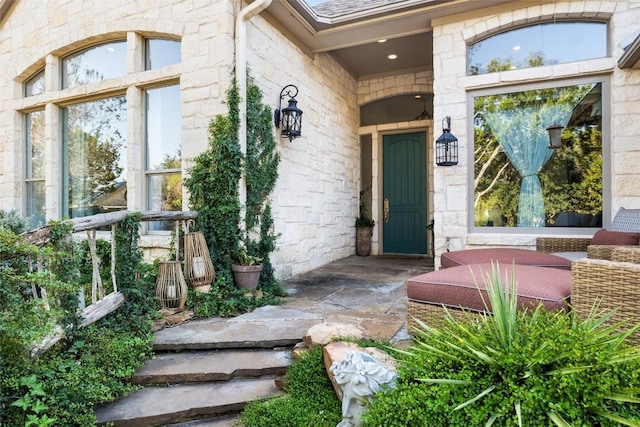 property entrance with stone siding and a shingled roof