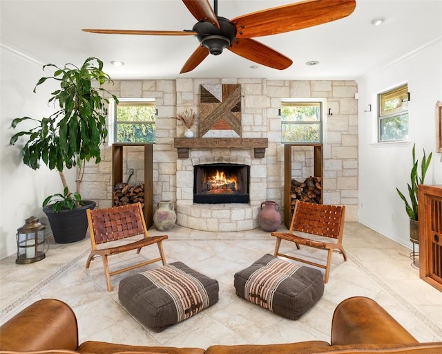 living room with crown molding, a fireplace, plenty of natural light, and baseboards