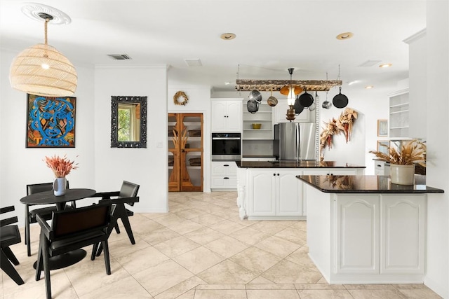 kitchen featuring visible vents, dark countertops, appliances with stainless steel finishes, hanging light fixtures, and white cabinetry