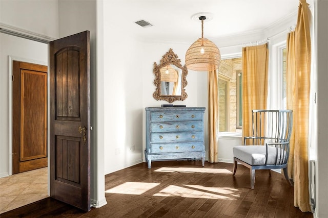 unfurnished room featuring ornamental molding, visible vents, baseboards, and wood finished floors