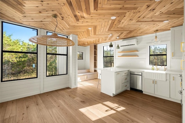 kitchen featuring a peninsula, light countertops, decorative light fixtures, and white cabinets