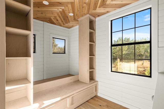 mudroom featuring light wood-style flooring, wood walls, and wood ceiling