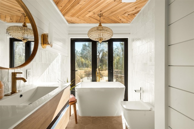 bathroom with wooden ceiling, a freestanding tub, toilet, a sink, and tile patterned floors