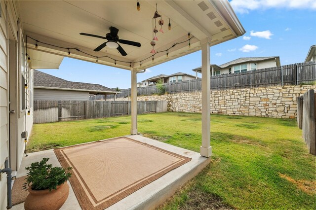 view of yard with a patio area, a fenced backyard, and a ceiling fan