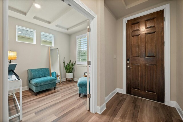 entryway featuring coffered ceiling, baseboards, and wood finished floors