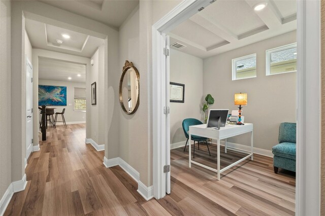 hallway with plenty of natural light, wood finished floors, and baseboards