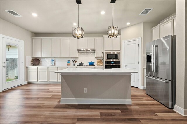 kitchen with white cabinets, under cabinet range hood, visible vents, and stainless steel appliances