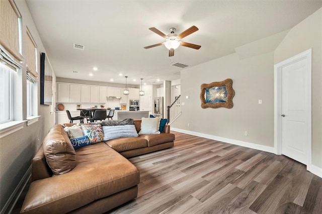 319 Victoria Peak Loop, Dripping Springs, TX 78620 - living room with stairs, a ceiling fan, visible vents, and wood finished floors