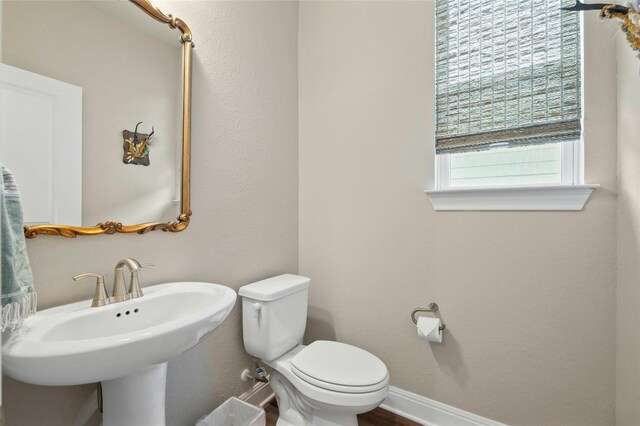 bathroom featuring a sink, toilet, and baseboards