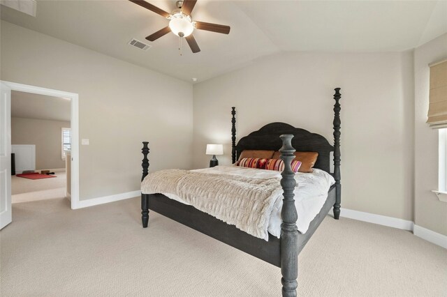 bedroom with lofted ceiling, baseboards, light carpet, and visible vents