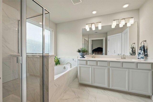 full bath featuring a garden tub, a sink, visible vents, a marble finish shower, and double vanity