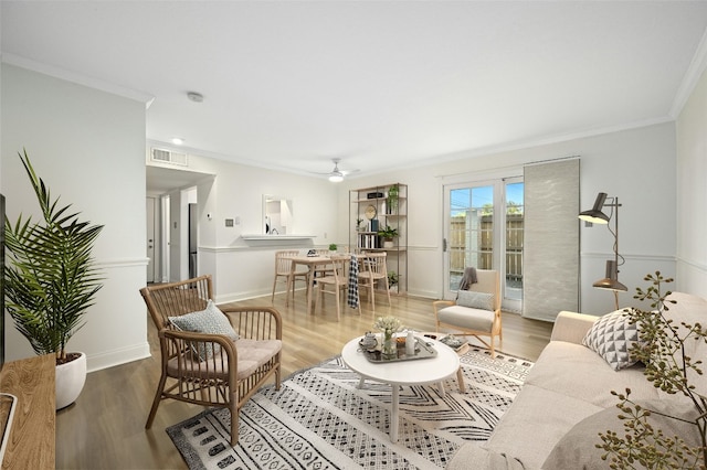 living room featuring light hardwood / wood-style floors, ornamental molding, and ceiling fan