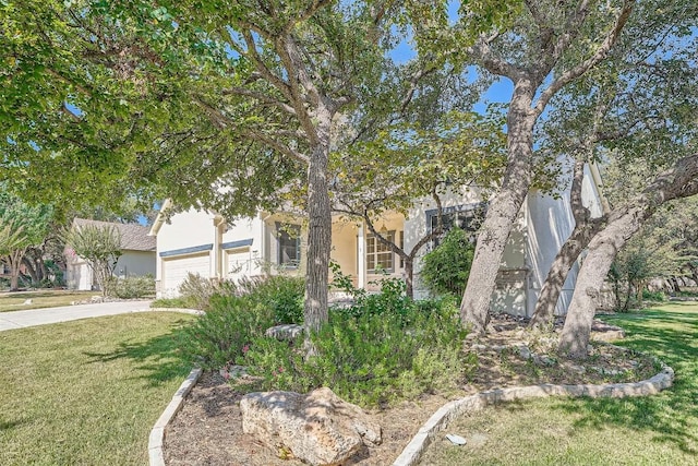 obstructed view of property with a front yard and a garage