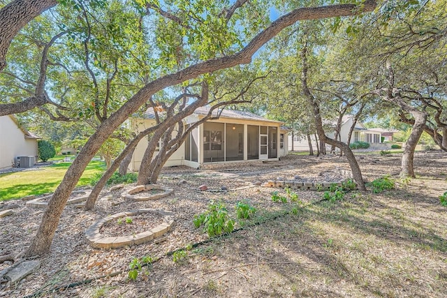 view of yard with a sunroom and central AC