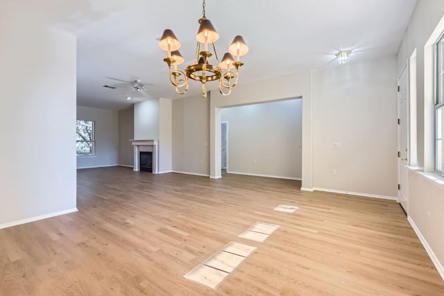 unfurnished living room featuring light hardwood / wood-style floors and ceiling fan with notable chandelier