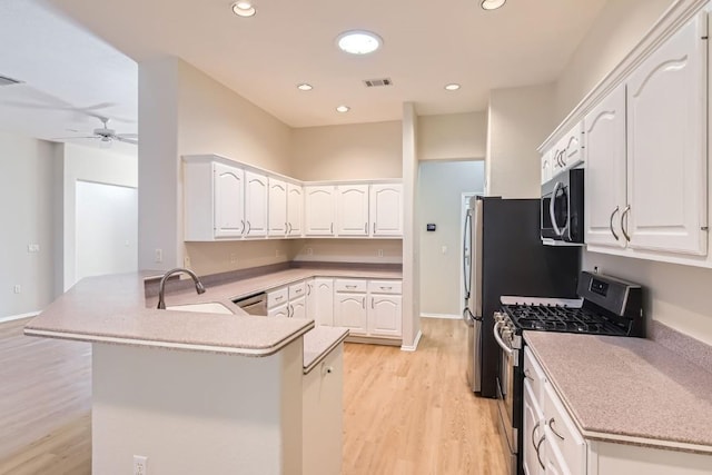 kitchen with kitchen peninsula, white cabinetry, light wood-type flooring, and appliances with stainless steel finishes