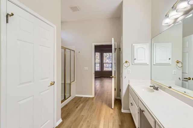 bathroom with vanity, wood-type flooring, and walk in shower