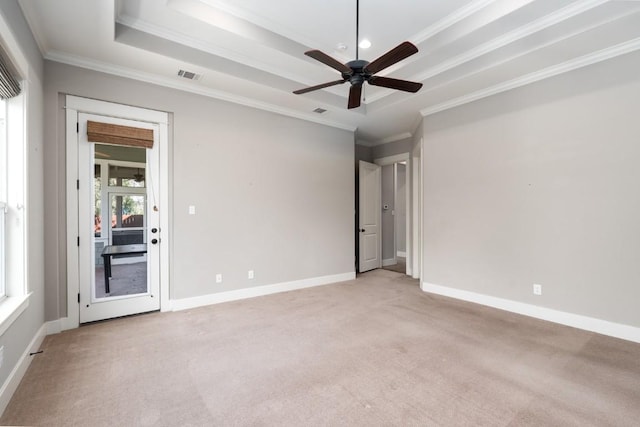 unfurnished room featuring a ceiling fan, baseboards, visible vents, a tray ceiling, and light carpet