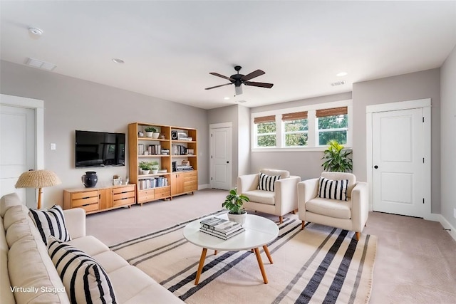 living room featuring baseboards, light colored carpet, visible vents, and ceiling fan