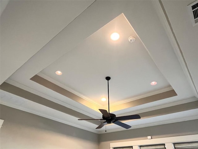 room details with ceiling fan, a tray ceiling, visible vents, and ornamental molding