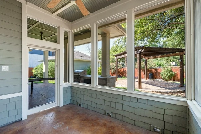 unfurnished sunroom with a ceiling fan