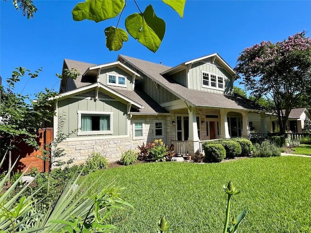 2204 Lindell Ave, Austin, TX 78704 - craftsman-style home with board and batten siding, a porch, a front yard, stone siding, and roof with shingles