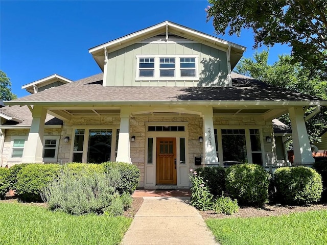 2204 Lindell Ave, Austin, TX 78704 - view of front facade featuring stone siding, board and batten siding, covered porch, and roof with shingles