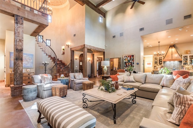 interior space with a towering ceiling, ceiling fan with notable chandelier, and beam ceiling