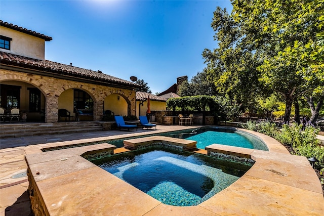 view of swimming pool featuring an in ground hot tub and a patio area