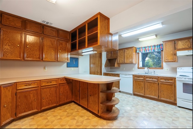 kitchen featuring sink, kitchen peninsula, and white appliances