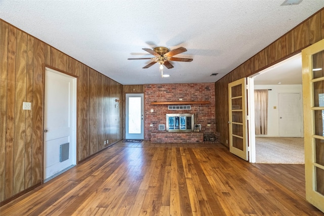 unfurnished living room with a textured ceiling, a fireplace, and dark hardwood / wood-style flooring