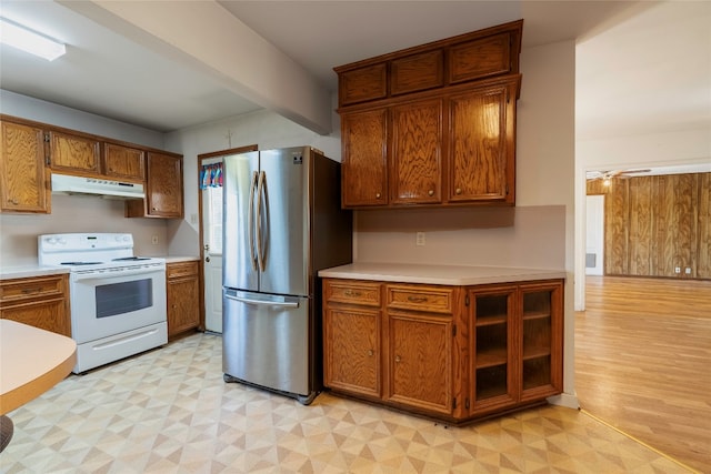 kitchen with electric stove, stainless steel refrigerator, and light wood-type flooring