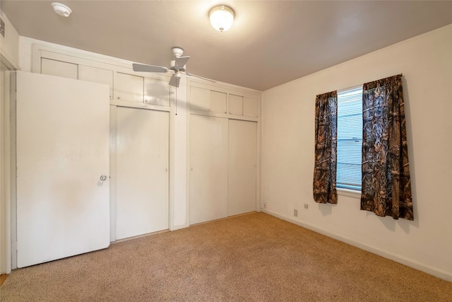 unfurnished bedroom with ceiling fan and light colored carpet