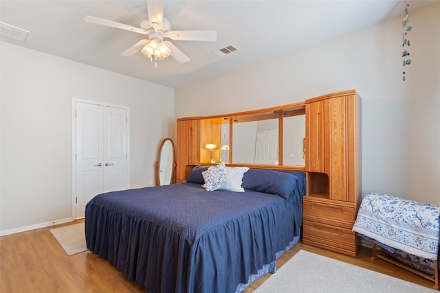 bedroom with ceiling fan, a closet, and light hardwood / wood-style floors