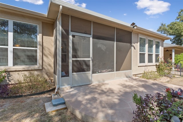 view of home's exterior featuring a sunroom and a patio area