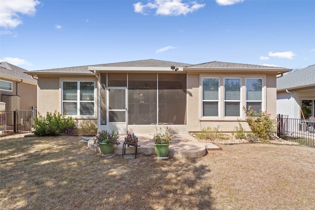 back of house with a yard and a sunroom