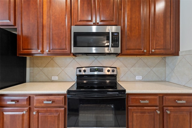 kitchen with stainless steel appliances and tasteful backsplash