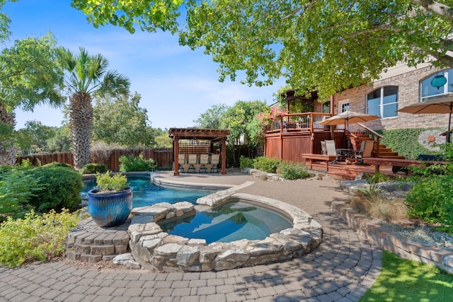 view of pool with an in ground hot tub, a patio area, a wooden deck, and a pergola