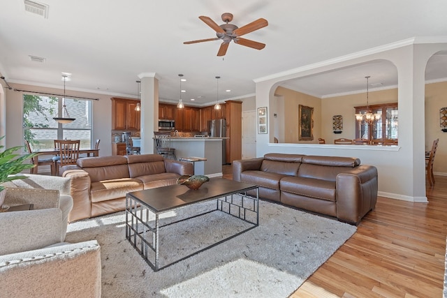 living room featuring ceiling fan with notable chandelier, crown molding, and light hardwood / wood-style floors