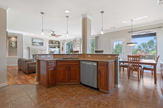 kitchen with dishwasher, a center island with sink, a fireplace, and sink